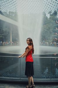 Portrait of woman standing by fountain outdoors