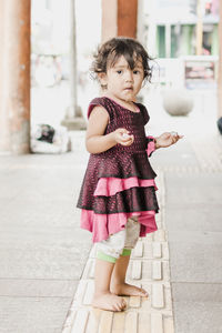 Full length portrait of girl dripping saliva while standing outside house