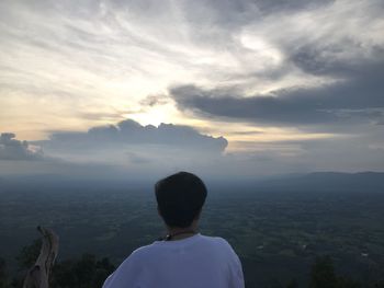 Rear view of man looking at sunset