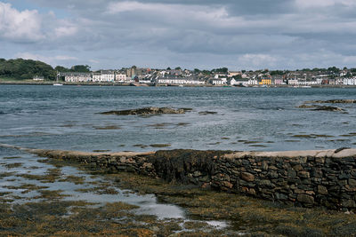 Scenic view of sea by buildings against sky