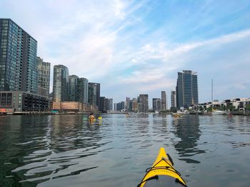 River amidst buildings in city against sky