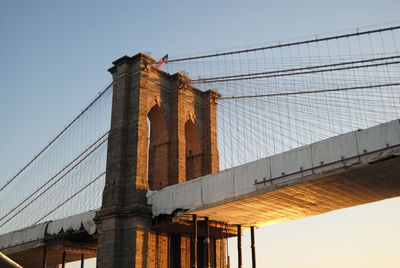 Low angle view of suspension bridge against clear sky