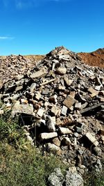 Surface level of rocky mountain against clear blue sky