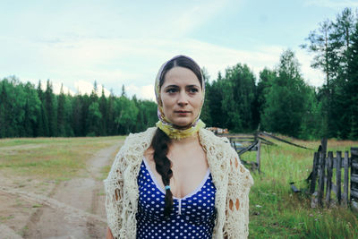 Rustic young woman in blue polka dot dress with cans