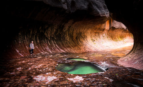 Senior woman standing inside cave