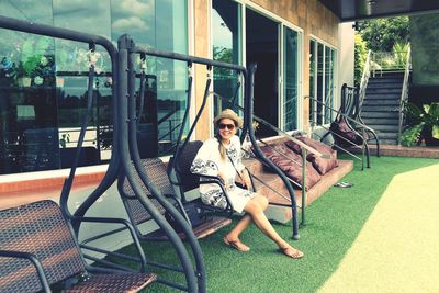 Portrait of smiling woman sitting on chair outdoors