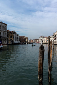 Canal amidst buildings in city against sky