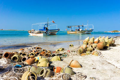 Fishing boats on beach against clear sky