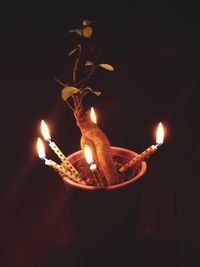 Close-up of lit candle in the dark