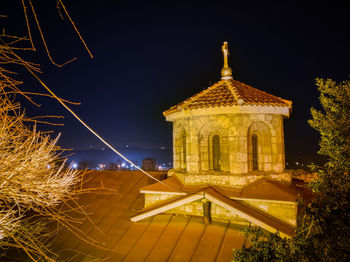 Low angle view of illuminated building against sky at night