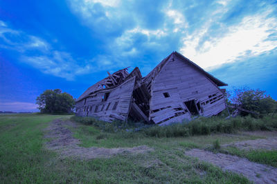 Abandoned house on field against sky