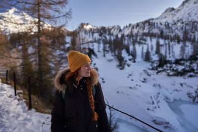 Rear view of woman standing on snow covered landscape