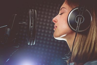 Close-up of woman singing in studio