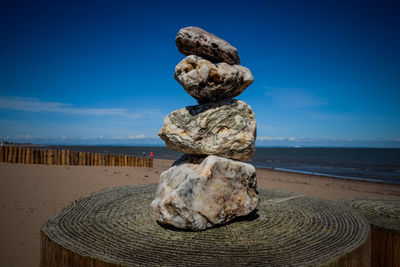 Stack of pebbles on beach against sky