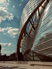 Low angle view of modern building against cloudy sky