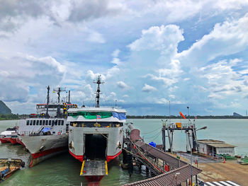 Ship moored at harbor against sky