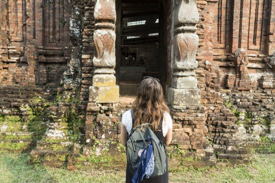 Rear view of woman standing at temple