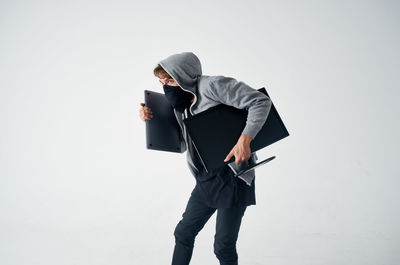 Man holding umbrella while standing against white background