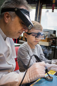 Worker teaching boy in workshop