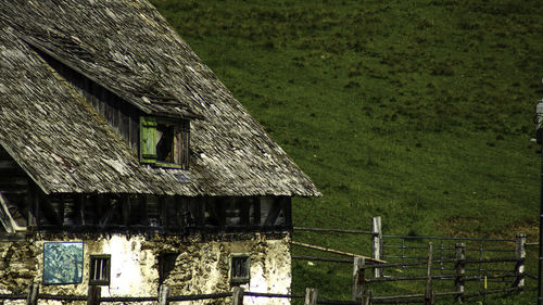 House on field against trees and houses