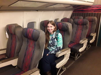 Portrait of smiling young woman sitting in airplane