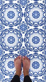 Low section of woman standing on patterned tiled floor