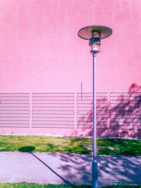 Street light against pink wall