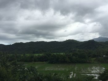 Scenic view of river by mountains against sky