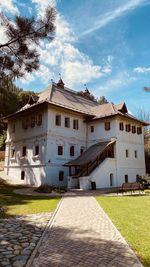 Footpath amidst buildings against sky. 