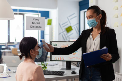 Side view of female doctor working in office