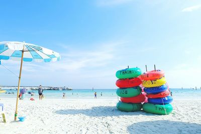 Stack on inflatable ring on beach against sky