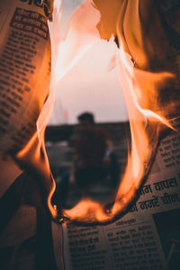 Close-up of lit candles on paper