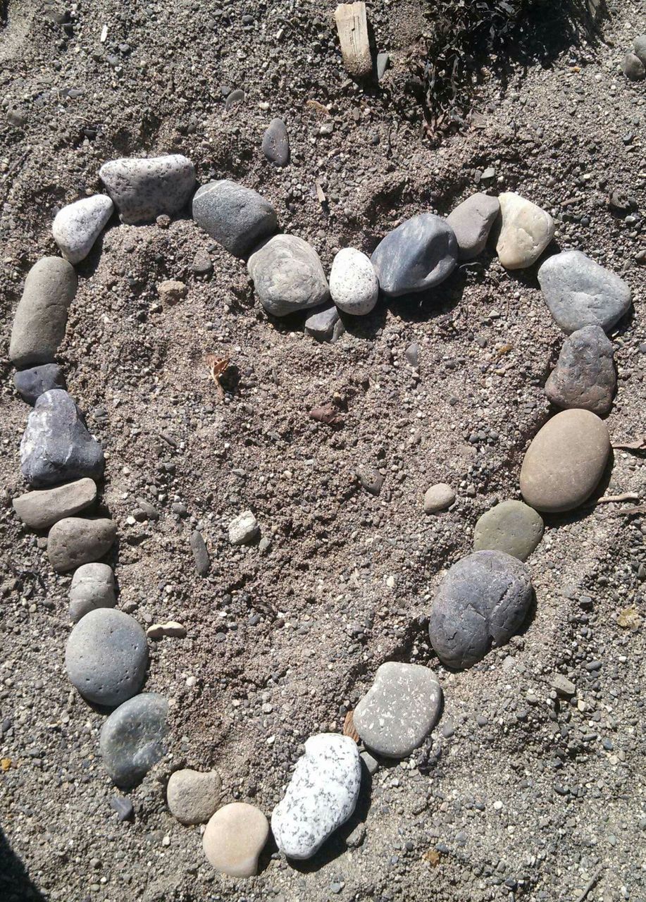 stone - object, pebble, large group of objects, abundance, high angle view, rock - object, stone, stack, beach, nature, field, day, sunlight, outdoors, tranquility, textured, still life, no people, close-up, sand