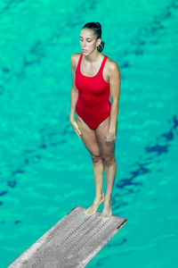 Swimmer standing on diving platform over swimming pool