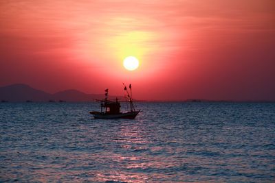 Silhouette boat in sea against sky during sunset