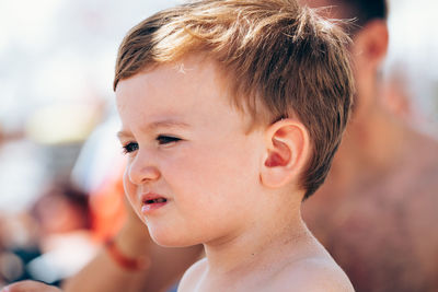 Close-up portrait of cute boy looking away outdoors