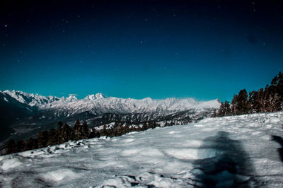 Scenic view of snowcapped mountains against clear blue sky