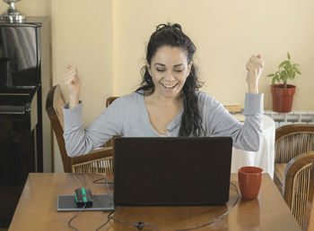 Woman using phone while sitting on table