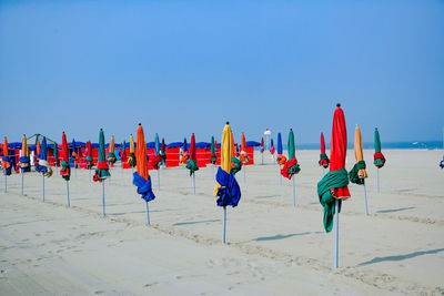 Multi colored umbrellas on beach against clear blue sky