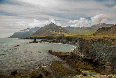 Scenic view of sea and mountains against sky