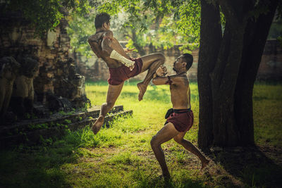 Shirtless warriors fighting on field