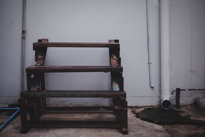 Empty bench against wall in old building