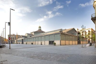 Street by buildings against sky in city