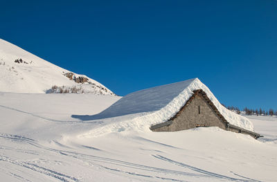 Scenic view of snowcapped mountain against clear blue sky