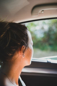 Portrait of woman seen through car window