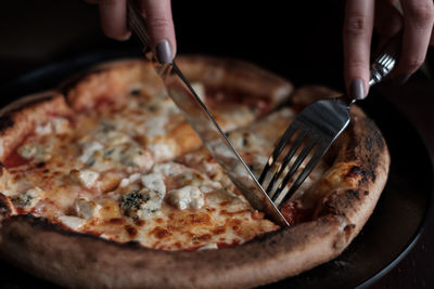 Female hands tasting delicious pizza