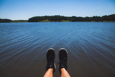 Low section of man on lake against sky
