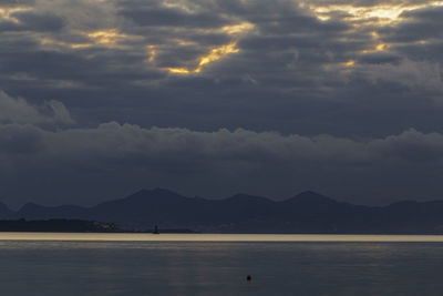 Scenic view of sea and mountains against sky