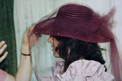 Cropped hands adjusting hat of young woman