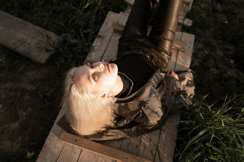 High angle portrait of young woman lying on wood
